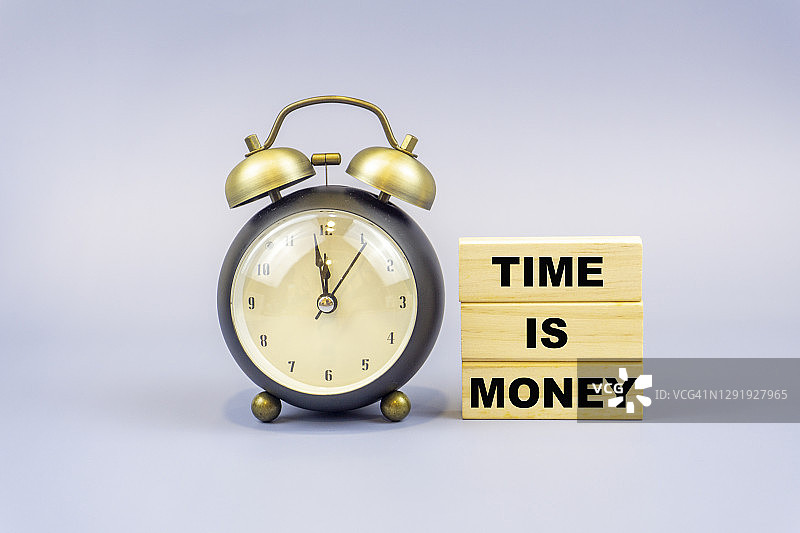带有桌钟的木块上的时间就是金钱字样，商业、金融概念背景图片素材