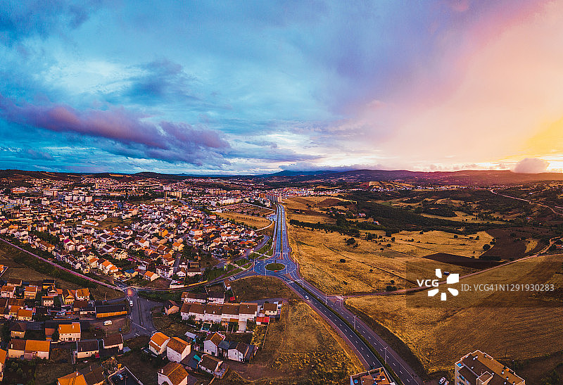 城市和原野上空的日落云彩图片素材
