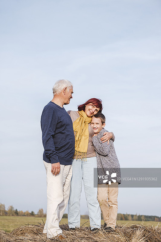 奶奶在干草堆上拥抱孙子图片素材