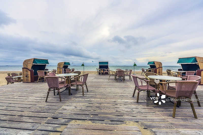 空旷的沙滩木板路，配有桌椅图片素材