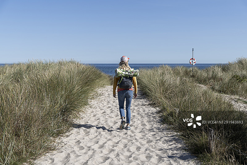 背包女人在海滩行走背影图片素材