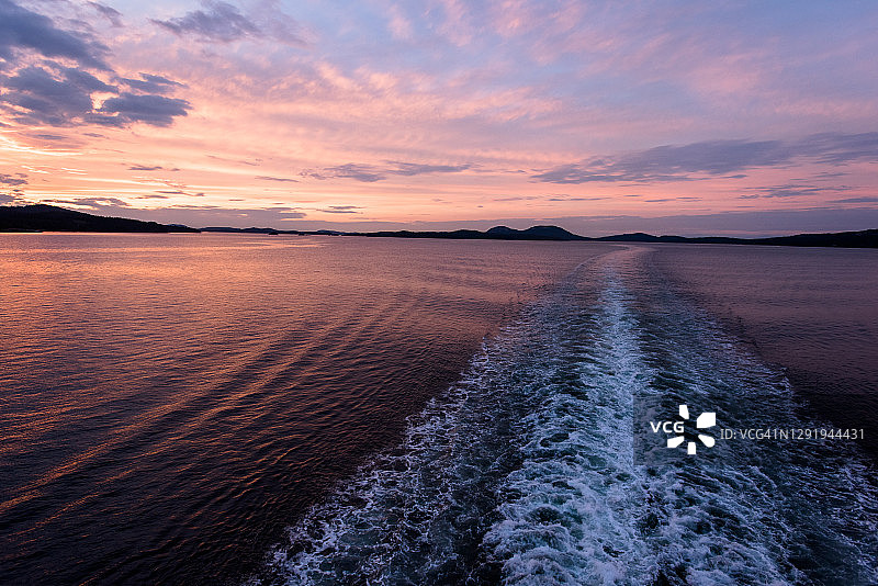 日出时分海洋上的渡轮水雾图片素材