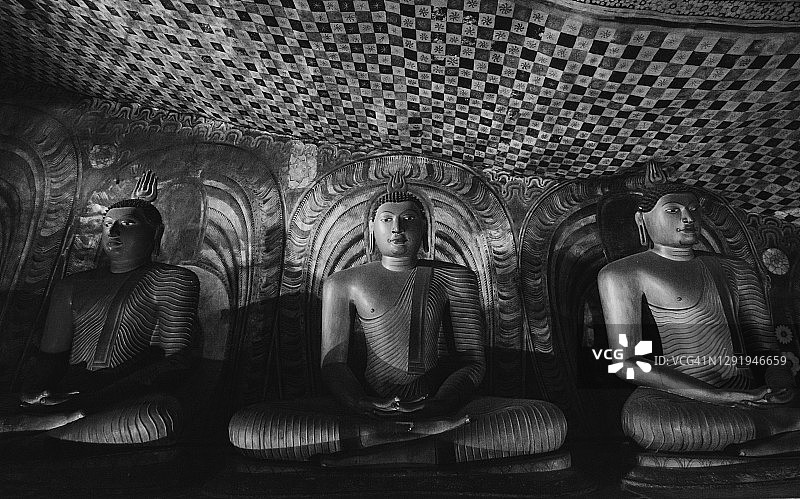 斯里兰卡丹布勒石窟寺内的精美坐佛像，神圣的朝圣地。黑白照片。图片素材