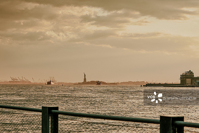 自由女神像天际线上空的暴风雨日落图片素材