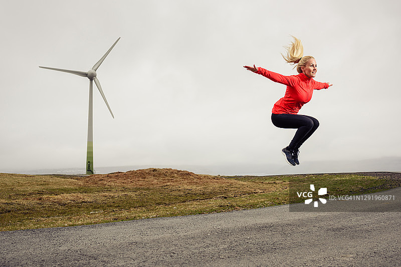 伸开双臂跳跃的女运动员图片素材
