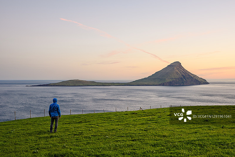 游客从草地海岸观察岩石岛屿图片素材