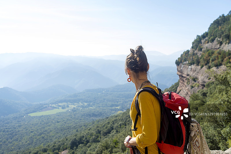 站在高山上欣赏风景的年轻女子背影图片素材