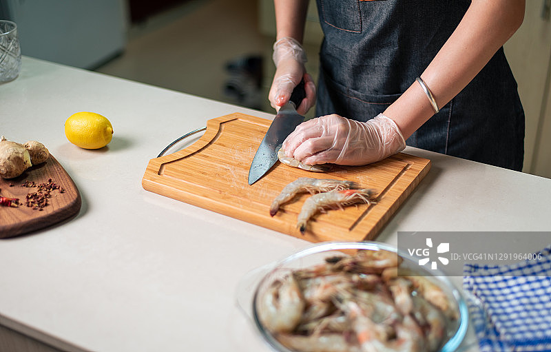 女人在厨房剥虾并清理以备烹饪图片素材