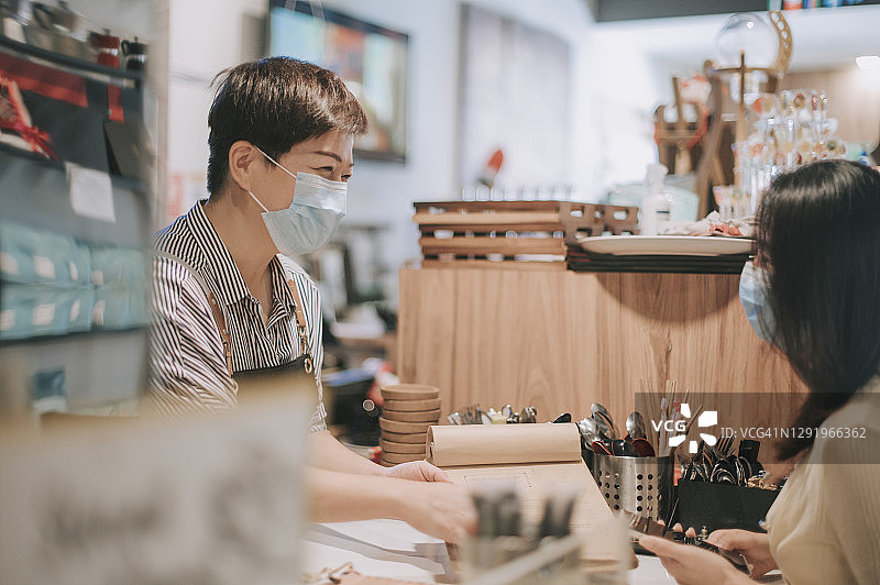 咖啡店主在柜台接受顾客订单图片素材