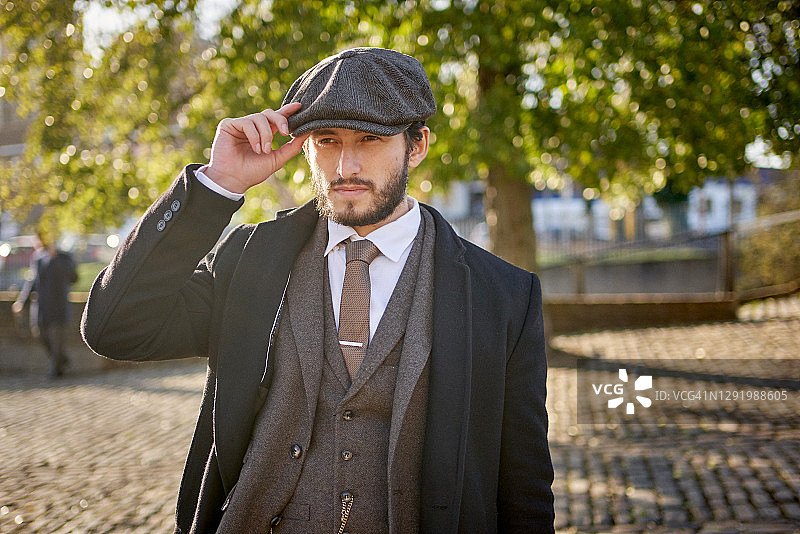 穿粗花呢西装和鸭舌帽的帅气男人肖像图片素材