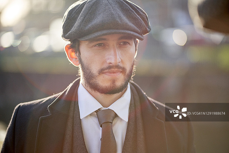 戴粗花呢套装和鸭舌帽的男人特写图片素材
