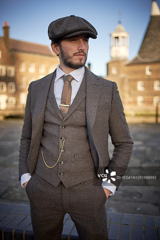 戴粗花呢西装和鸭舌帽的酷男人图片素材