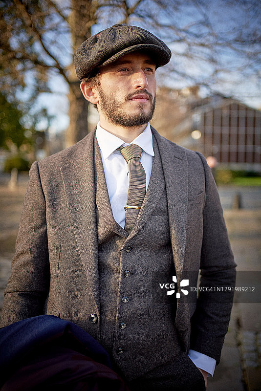 戴粗花呢西装和鸭舌帽的酷男人图片素材
