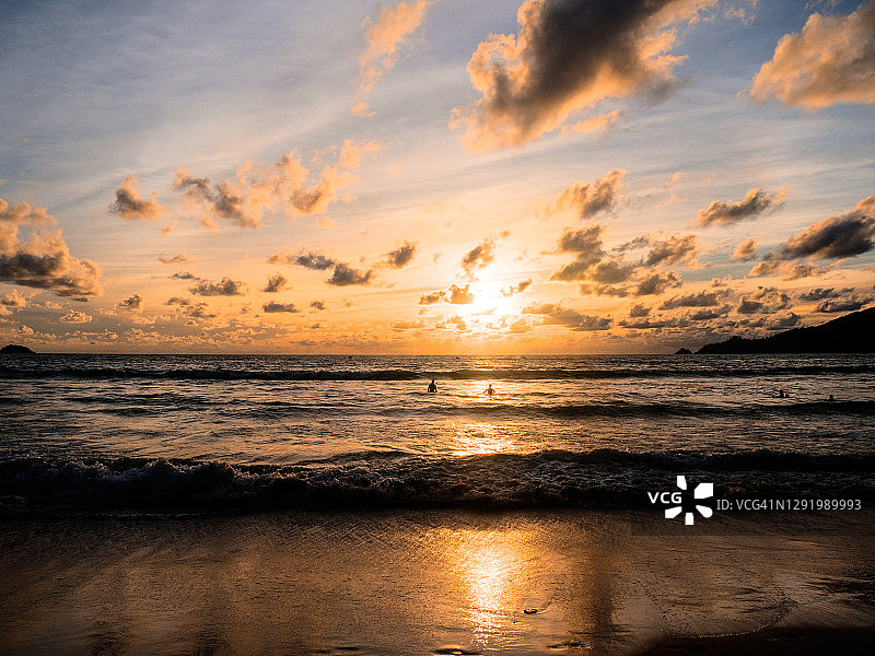 在泰国普吉岛芭东海滩欣赏日落的游客图片素材