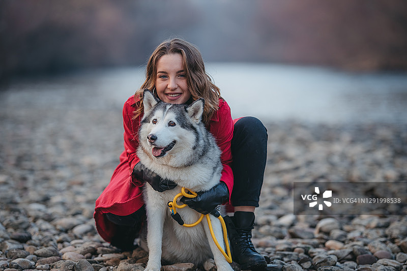 一位年轻女子与哈士奇犬在户外图片素材
