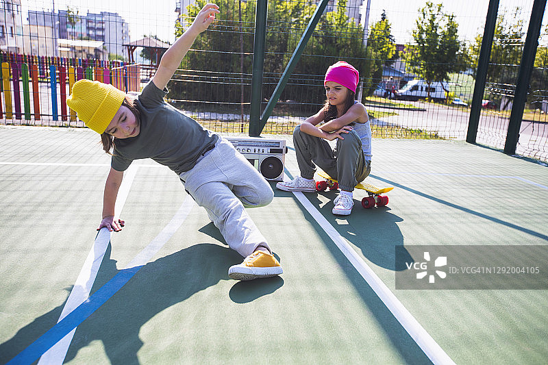 两个孩子在游乐场听音乐、玩耍和跳舞图片素材