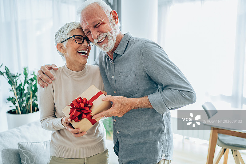 快乐的中年妇女收到丈夫的礼物图片素材