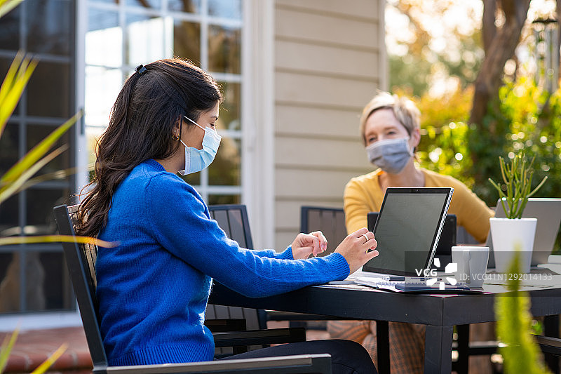 疫情期间在后院戴口罩居家工作的女人图片素材