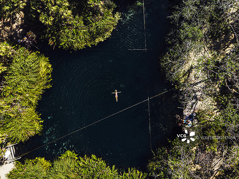 在天然井中游泳的女人航拍图片素材