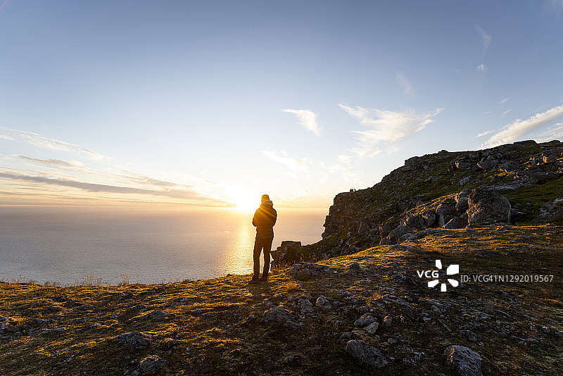 男子站在挪威罗弗敦群岛的瑞顿山上欣赏风景图片素材