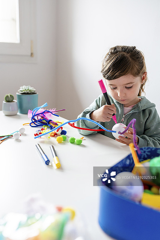 女孩学习用管道清洁器和泡沫球制作创意玩具图片素材