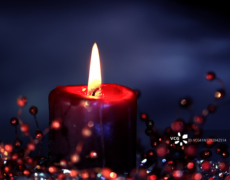 红色浆果装饰旁的红色蜡烛图片素材