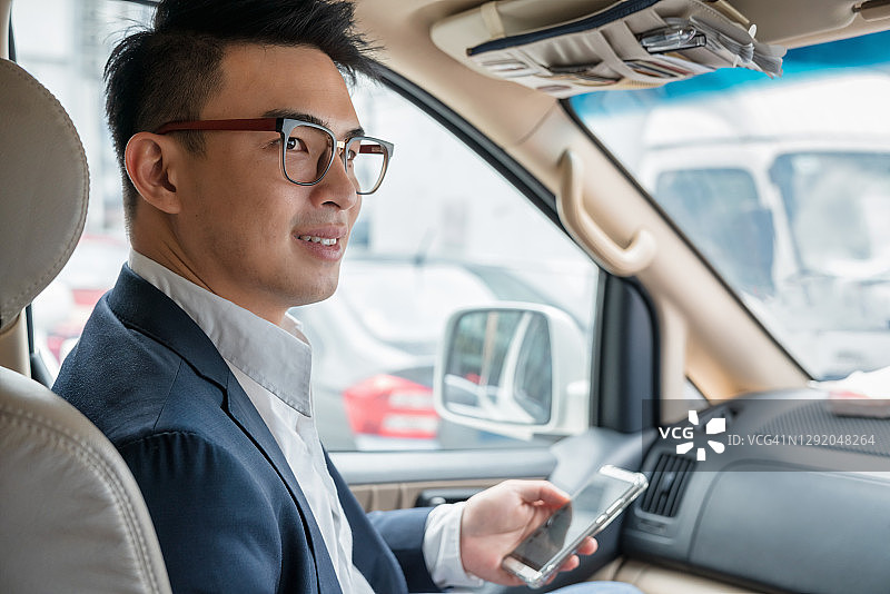 在吉隆坡乘坐Grab出租车的商人图片素材