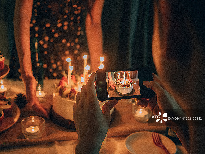 快乐的亚洲朋友在家中庆祝生日，分享蛋糕图片素材