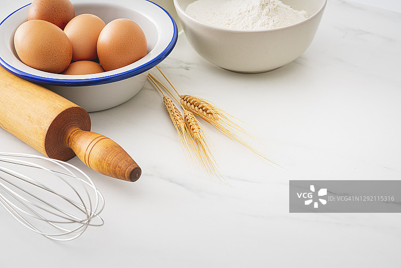 在白色厨房台面上烘烤自制面包，配有烹饪食材图片素材