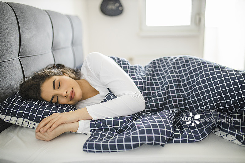 女士在舒适的床上放松身心图片素材