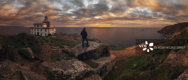 在西班牙菲斯特拉灯塔，朝圣者在“圣地亚哥之路”朝圣终点欣赏日落图片素材