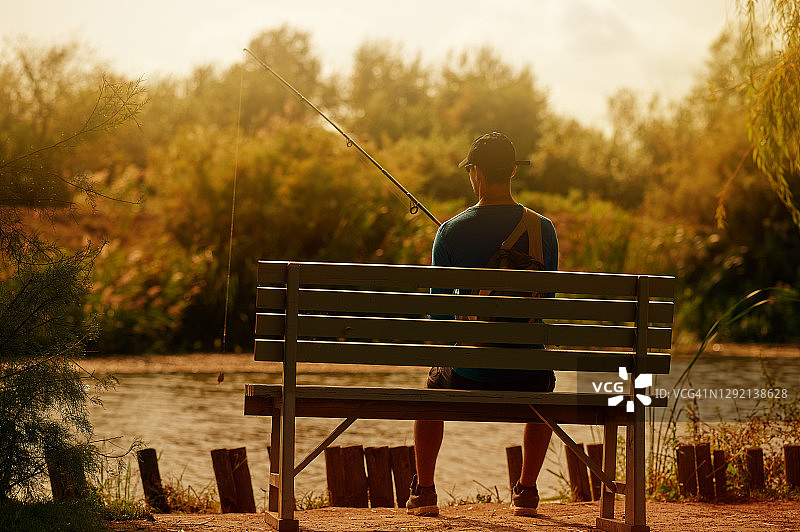 钓鱼的耐心：坐在长椅上图片素材