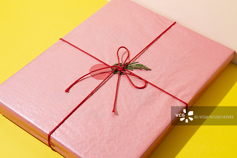 黄色背景上的粉色礼品盒（书籍）图片素材