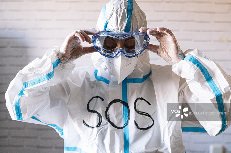 男护士穿着防护服和工作服，戴上防护眼镜图片素材