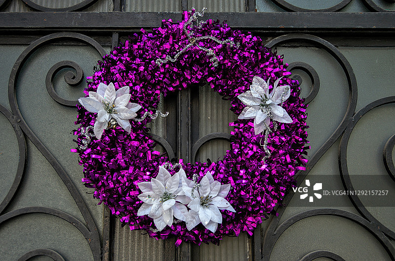 锻铁玻璃门上的紫红色金属丝圣诞花环图片素材
