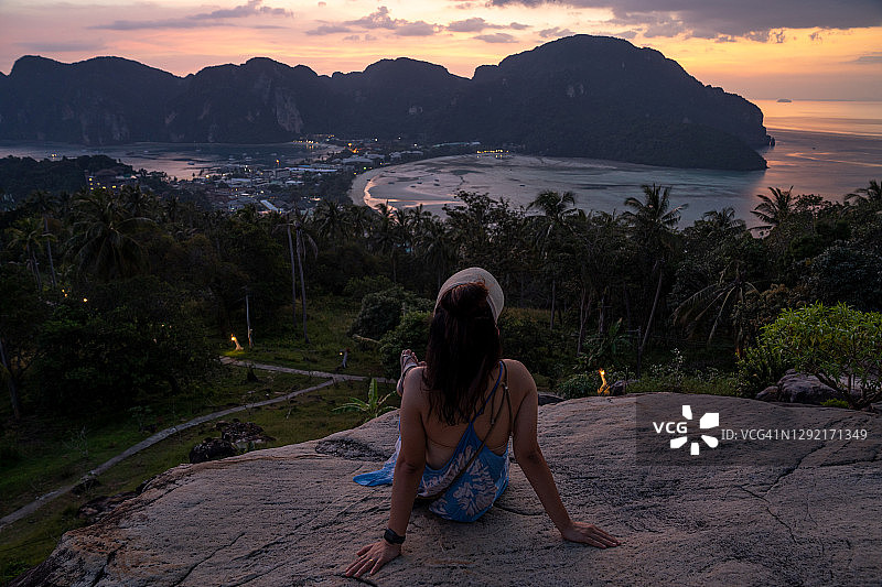 一个女孩在皮皮岛欣赏壮丽日落。背影。图片素材