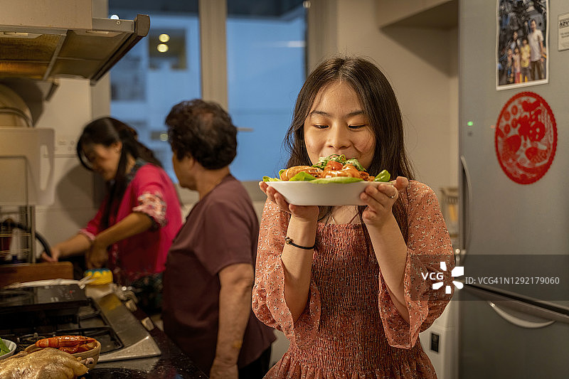 嗅着刚做好的食物的年轻中国女孩图片素材