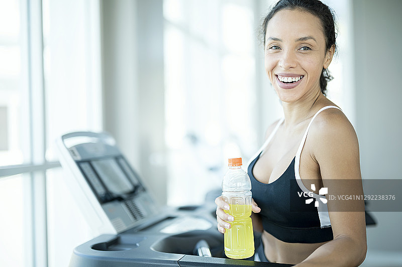 跑步后，女性手持运动型清凉饮料图片素材