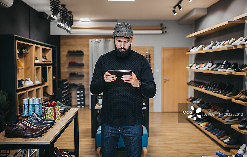 商人使用平板电脑经营线上鞋业图片素材