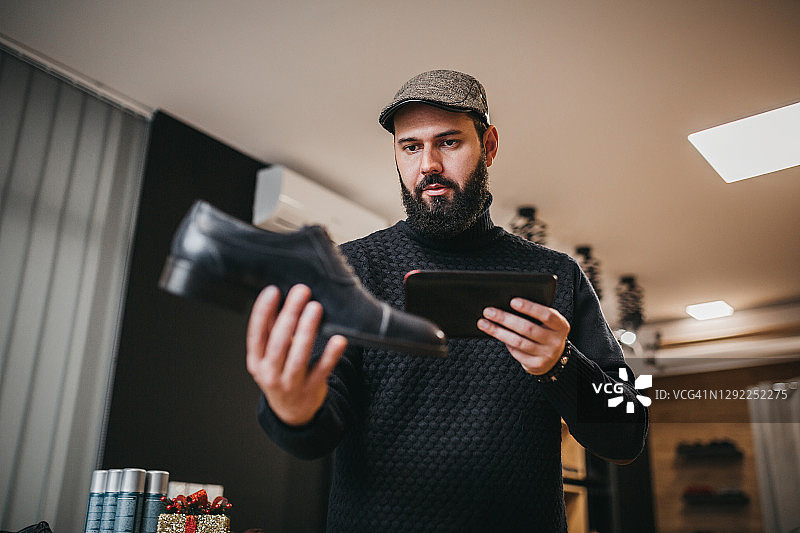 商人使用平板电脑经营线上鞋业图片素材