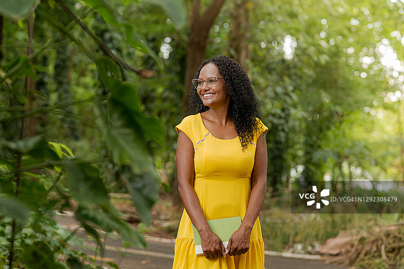 公园里戴眼镜穿黄裙的黑人女人图片素材