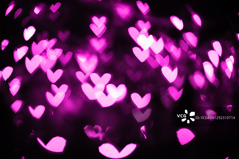 紫色心形灯光的散景背景。情人节抽象卡片。图片素材