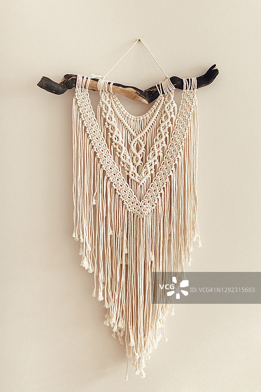 米色墙上手工棉质流苏装饰图片素材