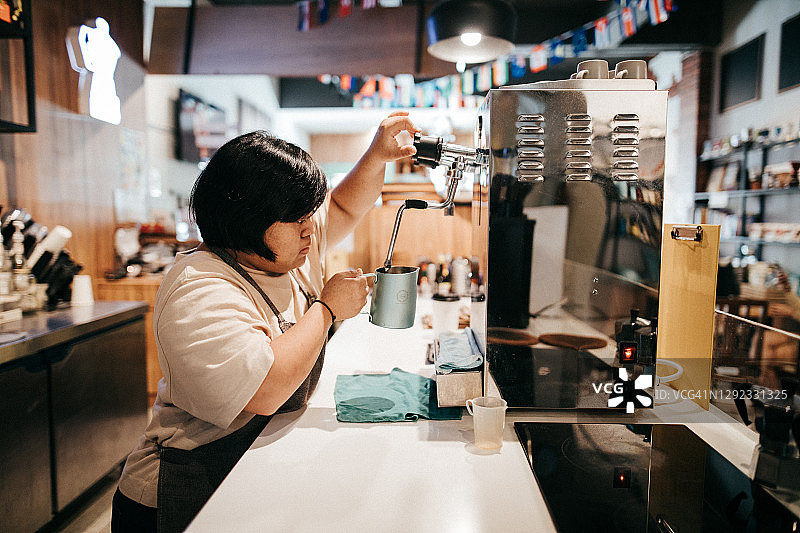 在咖啡馆工作的亚洲残疾女孩图片素材
