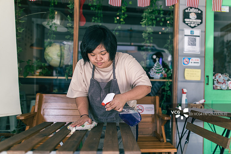 亚洲残疾女孩与同事准备开咖啡馆图片素材