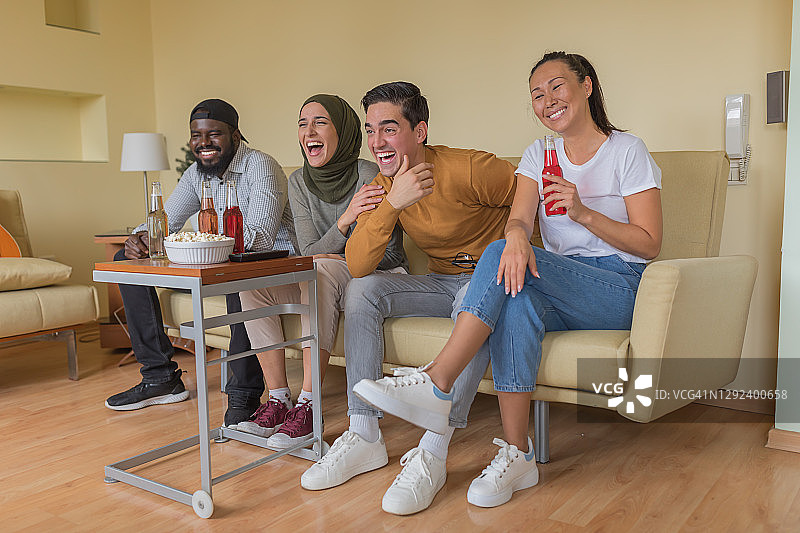 一群快乐的多种族年轻朋友正在家里观看恐怖电影图片素材