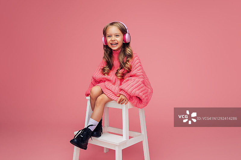 快乐儿童在工作室听音乐并微笑图片素材