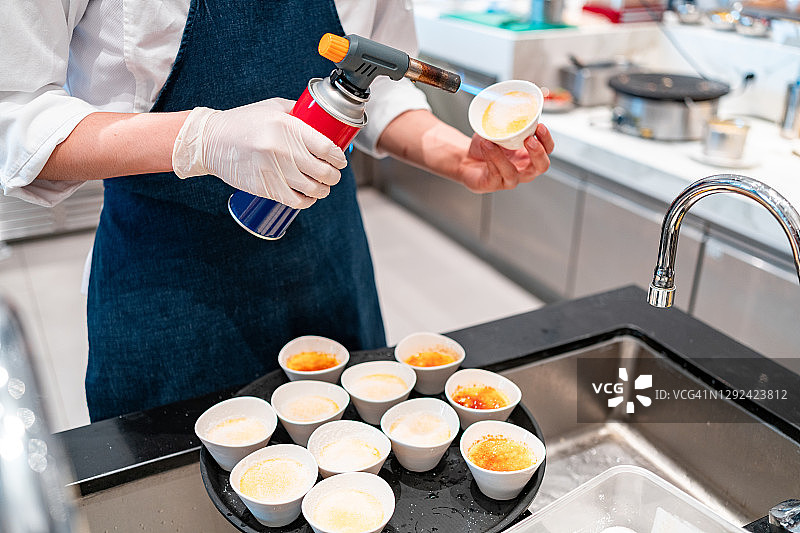 用喷枪火焰在焦糖布丁上烤糖图片素材