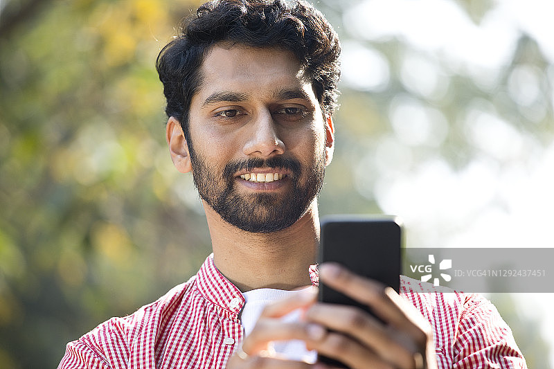快乐的印度男子使用手机图片素材