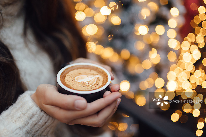 圣诞节期间女人手捧咖啡杯图片素材